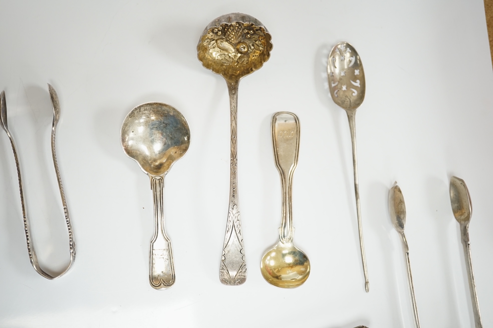 Ten assorted items of silver flatware including a mid 18th century mote spoon by Elizabeth Jackson?, 14.8cm, a George IV caddy spoons, two pairs of sugar tongs, four condiment spoons, a butter knife and sauce ladle, 6.8o